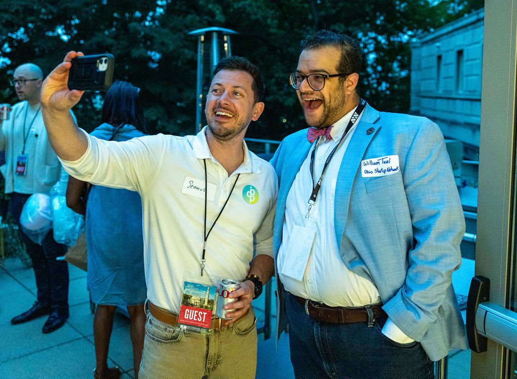 Attendees taking a selfie on the terrace at Rooted & Rising